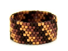 a close up of a bracelet made out of beads on a white surface with brown and tan squares