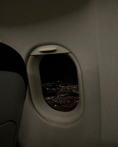 an airplane window looking out at the city lights