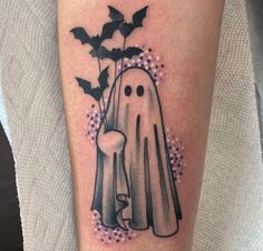 a tattoo with a ghost and bats on it