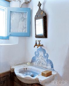 a bathroom with a sink, mirror and soap dish on the counter in front of it