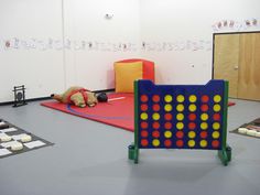 an indoor play area with several pieces of furniture and games on the floor in front of them