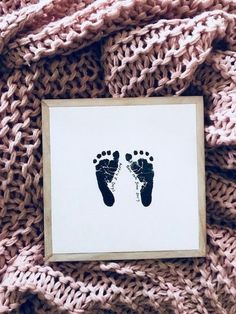 a baby's foot print is placed on top of a knitted pink blanket