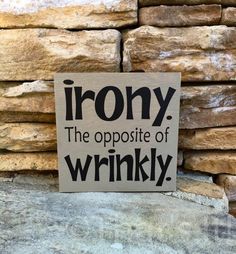 a sign that says irony the opposite of wrinkly on top of some rocks