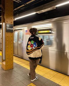 a woman is waiting for the subway to stop