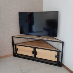 a flat screen tv sitting on top of a wooden stand in front of a wall