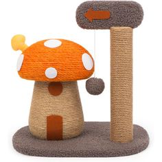 a toy mushroom is on the ground next to a cat scratching post with a stick