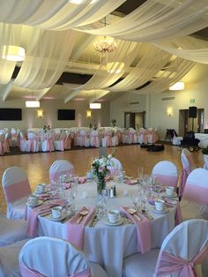 the banquet hall is decorated with pink and white linens