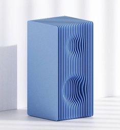 a blue box sitting on top of a white table next to a square shaped object