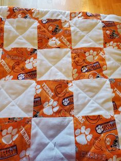 an orange and white quilt with paw prints on it