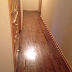 an empty hallway with wood floors and white walls