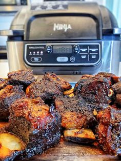 some meat and potatoes are on a cutting board next to an electric pressure cooker