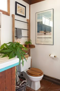 a bathroom with a wooden toilet seat next to a plant