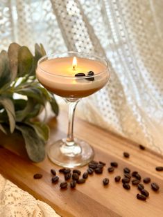 a glass filled with coffee sitting on top of a wooden table