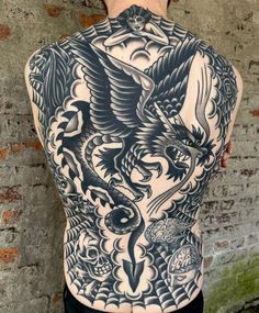 the back of a man's body with tattoos on it, and an eagle