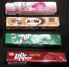 four different types of candy bars lined up in a row on a black table top