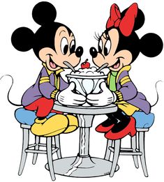 two mickey and minnie mouse sitting at a table