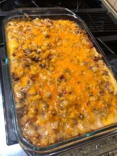 a casserole dish sitting on top of an oven with cheese and other toppings