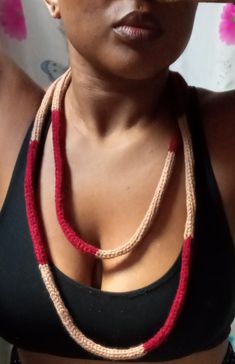 a woman wearing a black top and red necklace