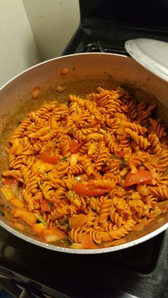 a pan filled with pasta and vegetables on top of a stove