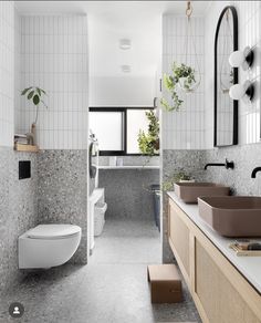 a bathroom with two sinks and a toilet next to each other in front of a window