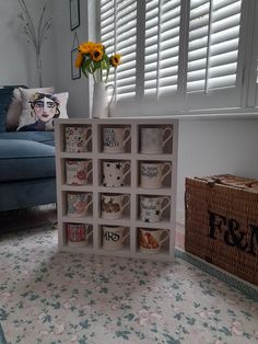 there is a coffee cup display in the living room with sunflowers on the window sill