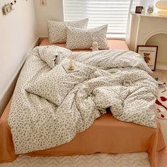 an unmade bed in a bedroom with pillows and blankets on top of the bed