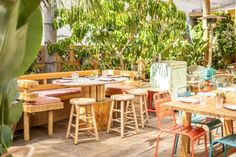 an outdoor dining area with wooden tables and chairs