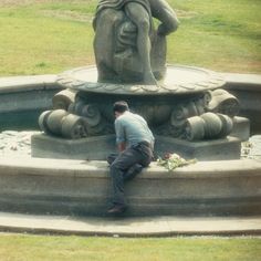 a man kneeling down in front of a statue