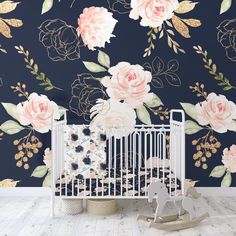 a white crib in front of a floral wallpaper with pink roses on it