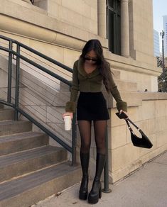 a woman in tights and boots is walking down the stairs with her handbag