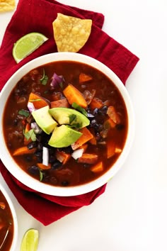 a white bowl filled with black beans, avocado and tortilla chips