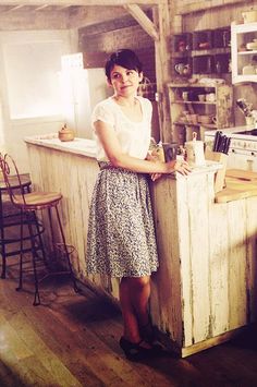 a woman standing in front of a kitchen counter