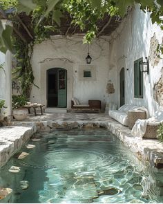 an outdoor swimming pool surrounded by greenery and stone walls with doors leading to the outside