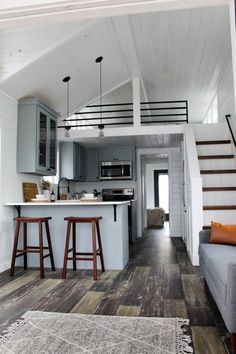 the interior of a tiny home with stairs leading up to the kitchen and living room