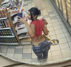 a woman is looking at her cell phone in the store's selfie mirror