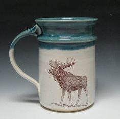 a blue and white mug with a moose drawn on it