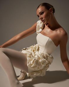 a woman in white dress sitting on the floor