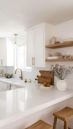 a kitchen with white counter tops and wooden stools