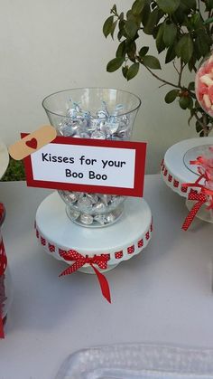 a table topped with vases filled with flowers and candy canes next to a sign that says kisses for your boo