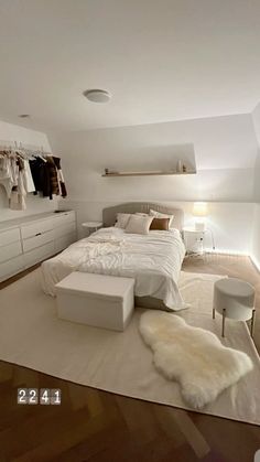 a large white bed sitting in the middle of a bedroom