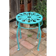 a blue metal table sitting on top of a brick floor