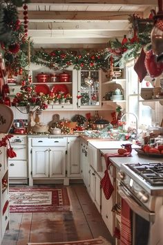 the kitchen is decorated for christmas with red and green decorations on the ceiling, along with white cabinets