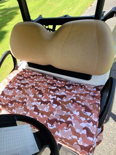 the driver's seat on a golf cart is covered with an orange and white fabric