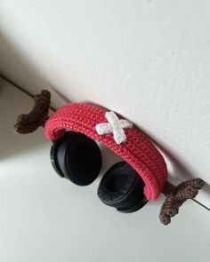 a crocheted hat and pair of headphones hanging on the wall