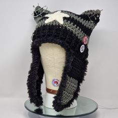 a knitted hat on top of a mannequin's head with buttons