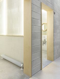 two open doors in the middle of a room with white walls and concrete flooring