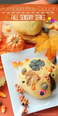 a pumpkin play dough is on a plate with fall leaves and candy decorations around it