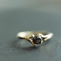 a gold ring with a black diamond on it