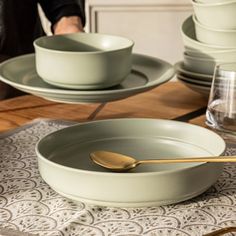 a table set with plates, bowls and utensils