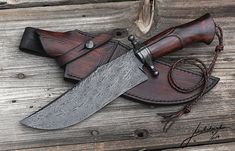 a knife and sheath laying on top of a piece of wood